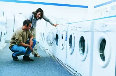 Man and woman shopping for washing machine.